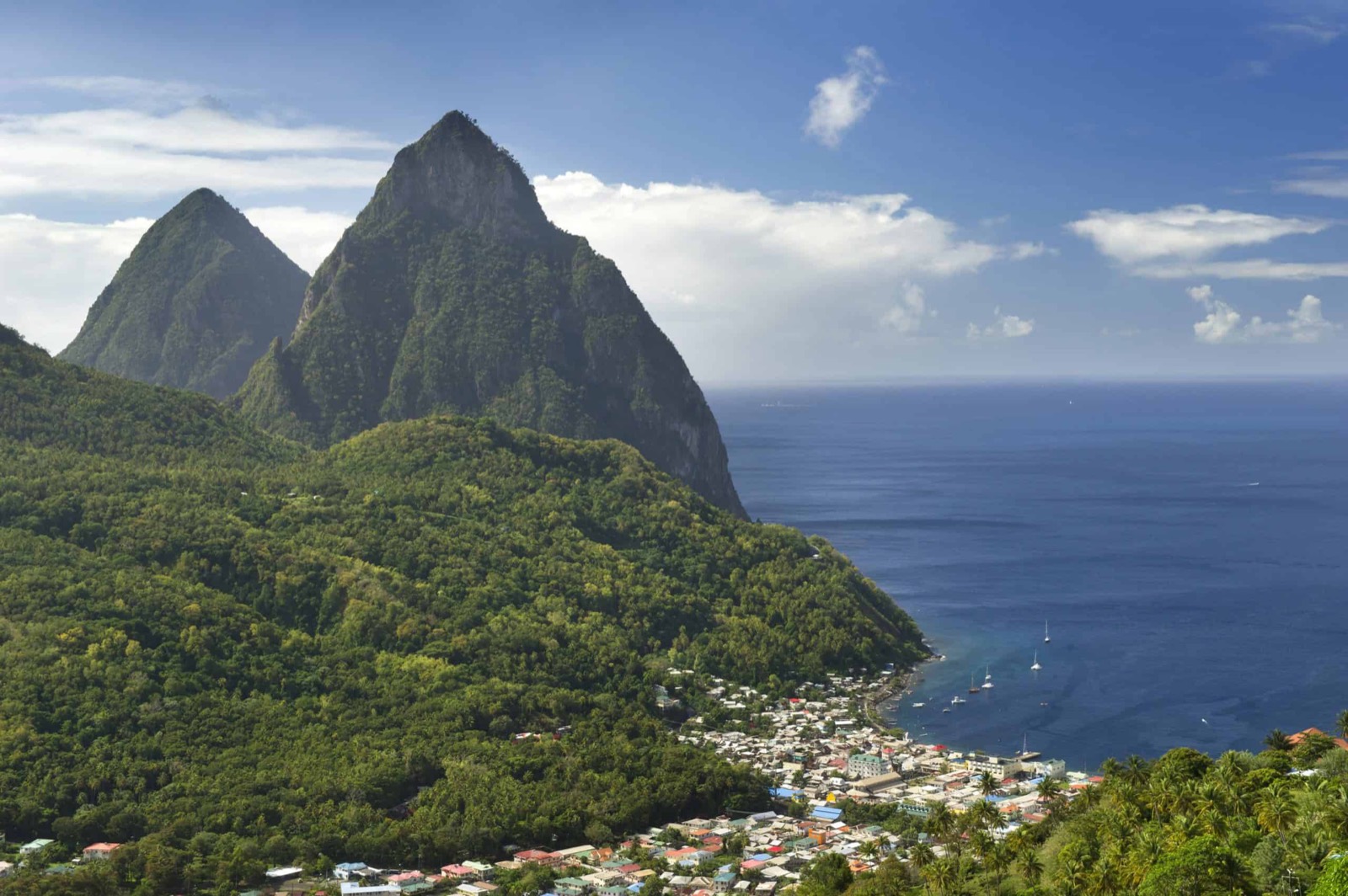 The Pitons rising over a calm Caribbean bay dotted with sailboats