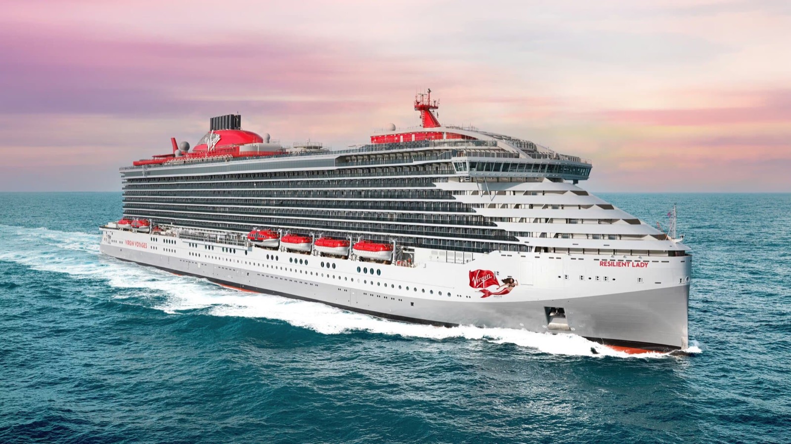 Virgin Voyages' Resilient Lady sailing under a pink sunset sky